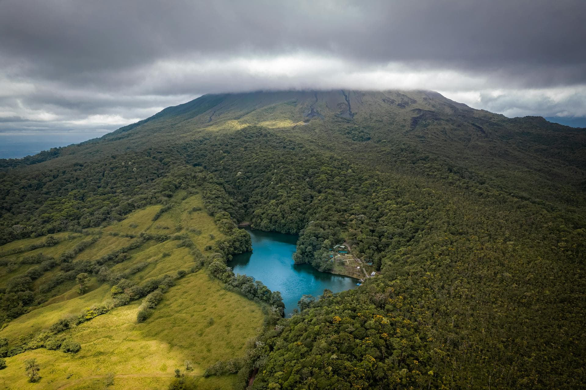 Aerial view of Arenal volcano with crater lake and cloud forest